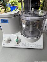 Full view of Braun CombiMax 650 food processor showing the main body, clear plastic mixing bowl, and control dials.