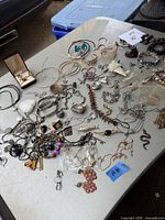 Photo of assorted costume jewellery spread on a table showing bracelets, earrings, rings, and necklaces.