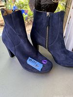 Side and front view of the blue suede boots showing texture, zipper, and heel form.