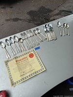 Full layout of the cutlery displayed on a table showing all pieces with the guarantee certificate included.