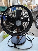 Front view of a black Nautica Home oscillating fan showing the 5 blades and the brand logo in the center of the grille.