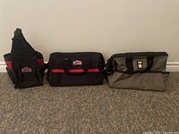 Three tool bags on carpeted floor showing various sizes and brands: two Jobmate black/red and one green Power Fist