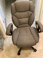 Front view of ergonomic office chair showing padded seat and backrest in grey tweed fabric, with cushioned armrests.