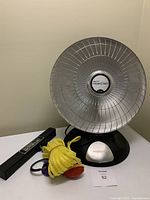 Photo showing a Presto HeatDish parabolic electric heater, the yellow Dipsy Diver with floating device and attached cord, and the Outboard MotorLok lock with keys on black keyring.