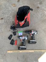 Two Porter-Cable cordless drills with attached 20V Lithium batteries, multiple drill bits, two battery chargers, and the carrying bag on a concrete floor, including a ruler for scale.