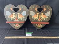 Two heart-shaped wooden shelves side by side, showing full front view with ruler for scale.