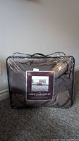 Photo of brown king size comforter set packaged in a clear zippered plastic carry bag with label showing 5-piece comforter set.
