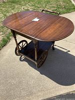 Full view of the vintage solid wood tea cart fully opened with all pieces visible including wooden handle and wheels.