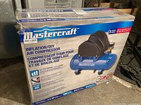 Front view of Mastercraft air compressor box showing product image and specifications.