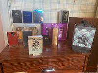 Full lot of unopened cologne boxes and a men's body care kit arranged on a wood surface.