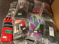 Multiple pairs of long leather gloves with some in original sealed plastic packaging, various colors including red, green, purple, black.