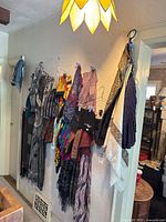 Multiple ladies fashion scarves hanging on hooks showing variety of patterns and colors
