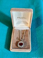 Necklace in pinkish velvet box with brand name 'Mappins' visible inside lid.