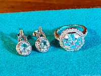 Photo of the sterling silver ring and pair of earrings with large cubic zirconia stones on a blue cloth background.