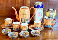 Full view of the vintage Asian fine bone china collection with coffee pot, teapot, cups, saucers, bowls, and large decorative vases and jar.