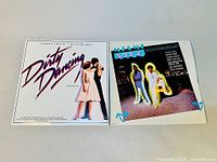 Photo showing front covers of both vinyl LPs: Dirty Dancing and Miami Vice original soundtracks laid flat side by side.