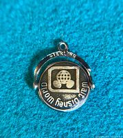 Close-up of the sterling silver spinner charm showing the Walt Disney World logo, engraved 'STERLING' on the outer ring, and detailed spinner mechanism.