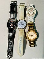 Four vintage wristwatches by Guess displayed side by side to show styles and bands.
