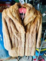 Front view of vintage red fox fur coat showing natural reddish-brown fur, wide notched collar, and button closure.