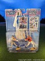 Front view of sealed blister package containing two plastic figurines (Cal Ripken Jr. and Brooks Robinson) and their matching collectible cards with Starting Lineup branding.