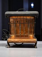 Front view of Redi-Heat electric heater showing copper reflector and cast iron side panels with cloth electrical cord.