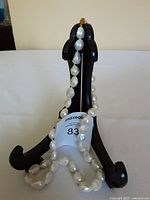 Baroque pearl necklace displayed on a black stand, showing the irregular shapes and luster of individual pearls as well as the gold-tone clasp.