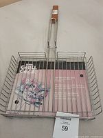 Top view of new BBQ veggie grill basket with packaging inside showing brand and usage details.