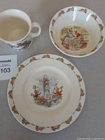 Photo showing the plate, bowl, and cup placed together featuring Bunnykins rabbit illustrations and border designs.