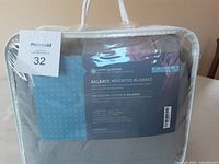 Photo of branded packaging and label of a Balance Weighted Blanket by Living Quarters Health & Wellness.