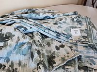 Folded upholstery fabric in shades of green displayed on table showing pattern and texture