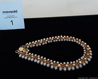 Full display of anklet showing pearls and ruby-like stones alternating along gold-tone base.