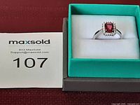 Ring size 6.5 displayed on a white cushion inside green and gray box, next to maxsold lot number card.