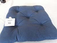 Single blue tufted cushion with visible tufting details and subtle dotted pattern.