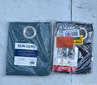 Photo of two packaged curtains in different colors, one labeled SUN ZERO and the other SOLARIS thermal.