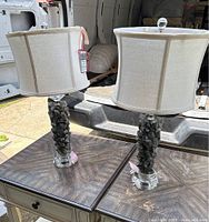 Pair of healing stones table lamps on wooden side tables showing stone bases and cream drum shades