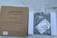 Photo showing the original box labeled "Detecto SlimTALK Talking Home Health Scale" along with the scale itself wrapped in plastic and protected with styrofoam.