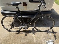 Full side view of a black Trek 7.3 FX hybrid bicycle showing frame, wheels, chain, and saddle.