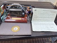 UPS 1997 90th Anniversary diecast truck model in acrylic case on wood base with gold plaque and medallion inside open presentation box, accompanied by official UPS letter.