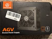 Front of the product box showing the Aresgame AGV Bronze Power Supply, 80 PLUS Bronze certification logo, 5-year warranty badge, and orange/black branding.