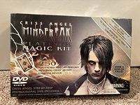 Front of the sealed box showing Criss Angel image and kit details including 250+ tricks and DVD.
