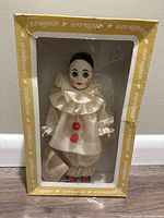 Effanbee Pierrot Clown doll inside original Effanbee branded box with front display window. Doll dresses in cream satin with red pom-pom details.