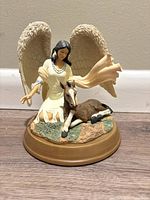 Front-side view of Native American angel figurine with wings and foal on a natural terrain base with golden brown rim.