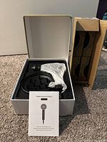 Boxed iRedBeau hair dryer with user manual visible on top and white wrapped dryer inside molded plastic packaging.