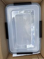 Top-down view of a clear plastic storage box showing lid and black side clips