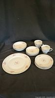 Full set including plates, cups, and saucers arranged on dark background