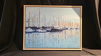 Front view of the oil painting showing boats at a marina with reflection in water within an ash wood frame.
