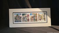 Full view of the four watercolor prints mounted on white mat board, showing all architectural scenes together unframed