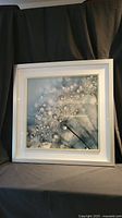 Front view of the framed picture showing the water droplet dandelion image and the white/silver frame.
