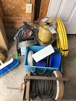 Overview of multiple cable and tubing spools in blue crate and on floor