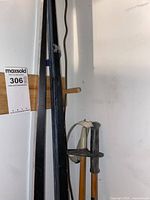 Cross country skis and poles hanging on a wooden rack in a white space